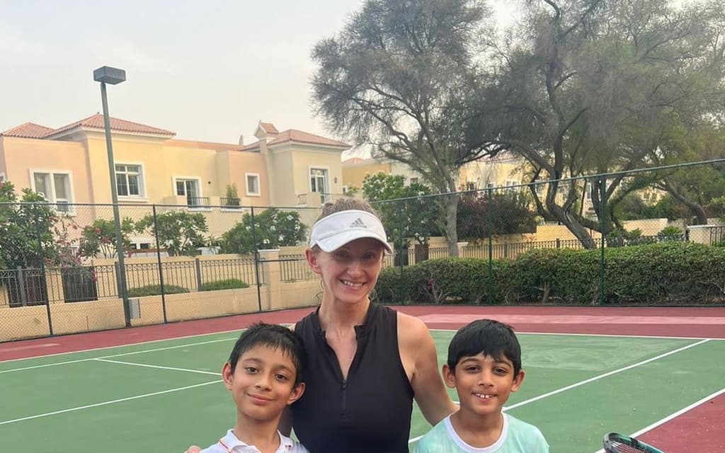 An AK Tennis coach with two junior players after a session